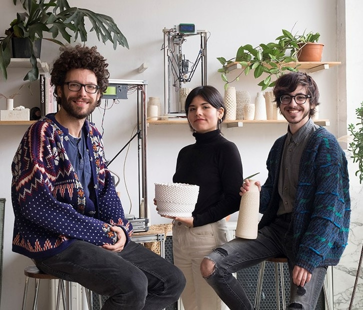 The Coudre team posing in their studio, among pieces, printers and plants.