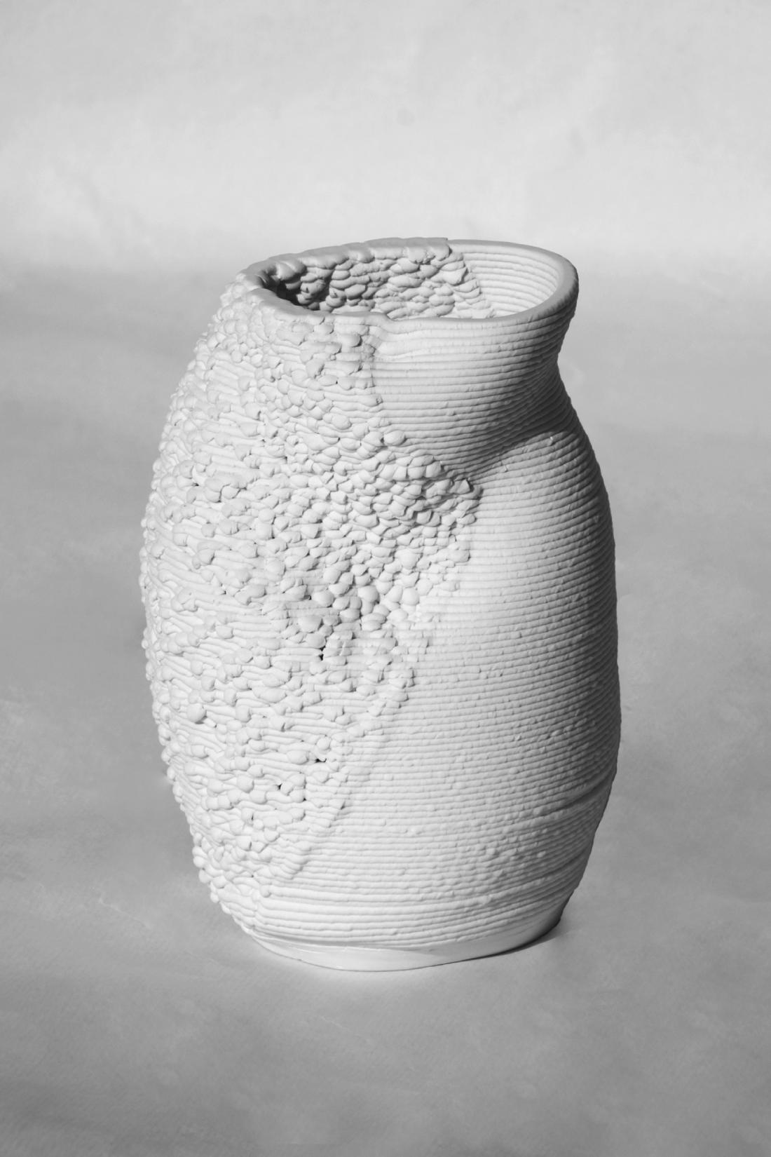 Second piece, made of printed porcelain. It has a beaker-like shape, with a patch of bumpy texture on the left.
