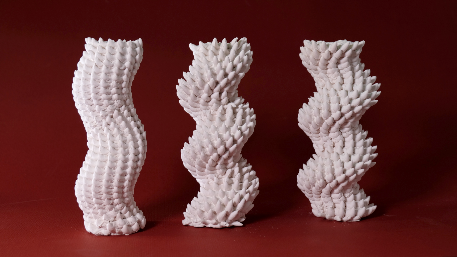 3 porcelain pieces, all tubular, but with different degrees of coiling and spikiness in their texture.