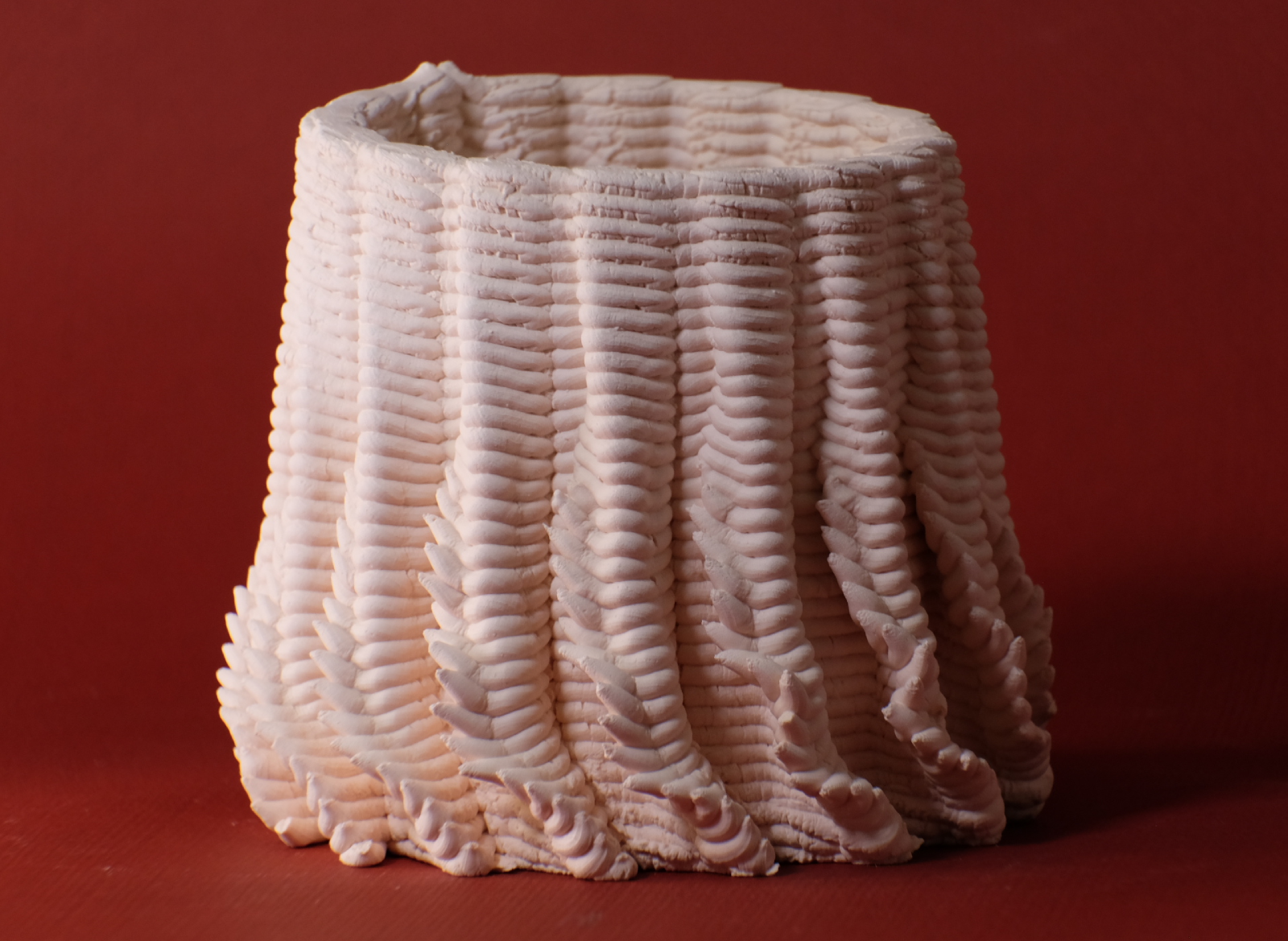 A porcelain piece with undulating vertical ridges.